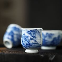 two blue and white cups sitting on top of a table