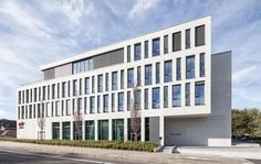 an office building with many windows on the front and side of it's facade