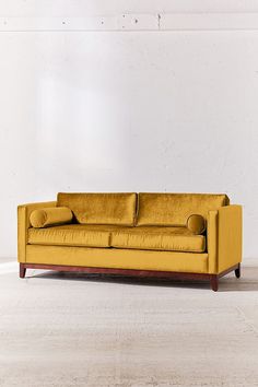 an orange couch sitting on top of a white floor