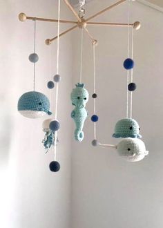 three crocheted sea animals hanging from the ceiling in a child's room