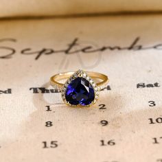 a blue stone ring sitting on top of a piece of paper