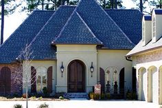 a large house with a lot of windows and lots of roofing on the front