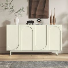 a white cabinet with two vases and a dog figurine sitting on top