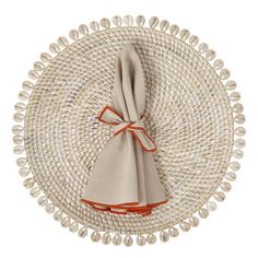 a placemat with an orange ribbon on it and some shells around the edge,