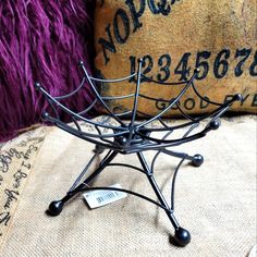 a decorative item sitting on top of a table next to a pillow and purple throw