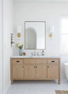 a bathroom with two sinks and a large mirror on the wall next to a bathtub