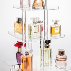 three tiered glass shelf with perfume bottles on it