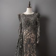 a dress on a mannequin stand in front of a gray wall