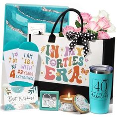 a gift bag with flowers, cards and other items in front of it on a white background