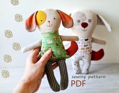 two stuffed animals sitting next to each other on top of a white table with paw prints