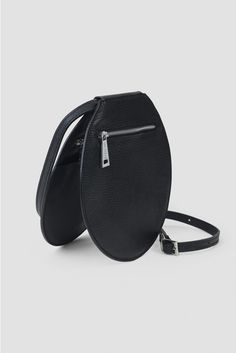 a black round bag with a zipper on the side and a strap at the bottom