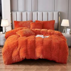 an orange comforter set on a bed in a room