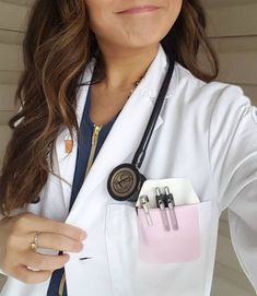 a woman wearing a white lab coat and holding a clipboard in her pocket with two clips attached to it