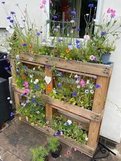 a wooden planter filled with lots of flowers