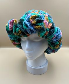 a white mannequin head with multicolored crocheted hair