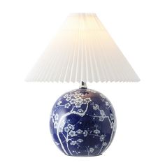 a blue and white vase with a lamp on it's side, in front of a white background