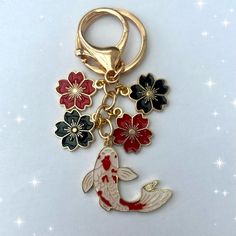 a gold keychain with an image of a fish and flowers attached to it