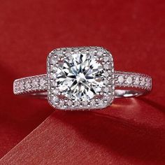 a diamond engagement ring sitting on top of a red cloth