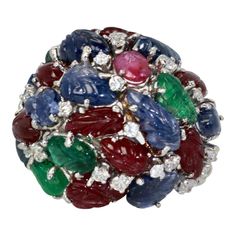 This is part of Chairish’s Fine Jewelry assortment.  Huge Tutti Frutti 18K Ring, Emeralds, Rubies, Sapphires and Diamonds  This huge Tutti Frutti Ring is special due to its size and the gorgeous carved gemstone leaves. There are Rubies, Emeralds, Sapphires with Diamonds interspersed throughout. Tutti frutti jewelry is rare and special as most of it was made in the 1920's-1930's by famous Jewelry houses and a short revival of Tutti frutti again in the 1960's when this ring was produced. I rarely Famous Jewelry, Diamonds Ring, Tutti Frutti, 4th Of July Wreath, Cocktail Rings, Diamond Rings, 1960s, Emerald, Ruby