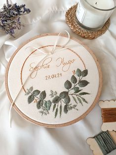 the embroidery is next to a candle and some other items