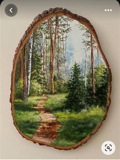 a painting of a path in the woods on a wood slice with grass and trees around it