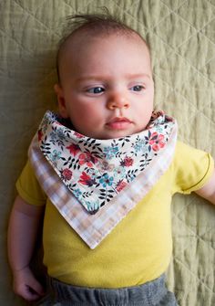 a baby wearing a bib laying on top of a bed