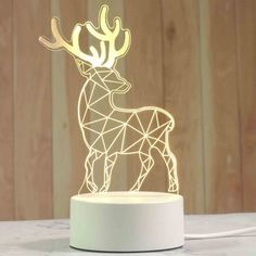 a white lamp with a deer on it's head and the light is turned on