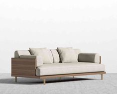 a white and brown couch sitting on top of a wooden frame