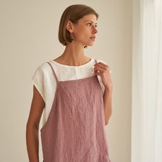 "Haven - everyday pinafore dress with endless styling possibilities. FEATURES: * comfy pockets * loose cut * dress length is 90 cm / 35.4\" (size S) * 100 % natural, certified linen fabric * dyed and washed in small batches * natural cotton yarns * biodegradable button frontline * handmade at a small studio in Europe COLORS: Dyed and washed in small batches, so the color will be unique and superb quality to each piece. Please check the color options on the side menu. SIZE GUIDE / BODY MEASUREMEN Essential Clothing Pieces, Linen Pinafore Dress, Pale Dogwood, Japanese Style Apron, Linen Apron Dress, Linen Pinafore, Linen Wrap Dress, Linen Sundress, Natural Linen Fabric