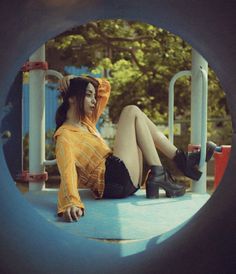 a woman sitting on top of a playground slide