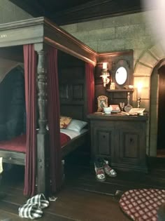 a bedroom with a canopy bed, dresser and other items on the floor in front of it