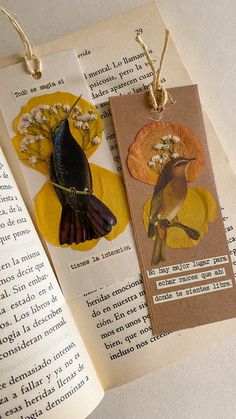 two bookmarks with birds on them are sitting on an open book, next to each other