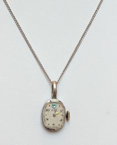 "This little pendant is a vintage (non-functioning) watch with great patina and an aqua blue Swarovski crystal. Purchase with or without the pictured 18\" sterling silver link chain." Vintage Silver Metal Jewelry And Watches, Vintage White Gold Nickel-free Necklace, Vintage Silver Jewelry And Watches For Gifts, Vintage Box Chain Jewelry For Formal Occasions, Vintage Formal Jewelry With Box Chain, Vintage Formal Box Chain Jewelry, Vintage Pendant Jewelry With Box Chain, Antique Silver Nickel-free Pocket Watch, Vintage Jewelry With Box Chain Pendant