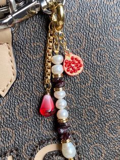 a close up of a key chain on a purse with beads and charms attached to it