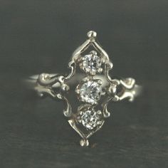 an antique style ring with three diamonds on it