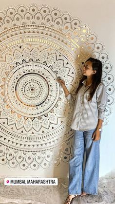 a woman standing in front of a wall with a large white doily on it