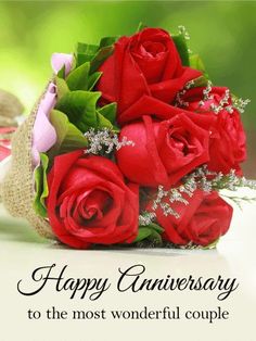 a bouquet of red roses sitting on top of a table next to a card with the words happy anniversary to the most wonderful couple