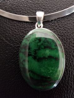 "Large Transvaal Jade stone set in sterling silver pendant. The stone is a dark green with darker stratification. The pendant is 1.5 inches long without the bail; with bail, it measures 1.8 inches. The pendant comes with a sterling silver stiff collar necklace. The necklace is 5.5 inches long and 4.5 inches wide. it has 2.6 inch gap so it can be easily put on or taken off. The collar has a maker's mark and is marked \"925\" and \"Mexico\". The collar can be worn with or without the pendant." Green Pendant Gemstones For Formal Occasions, Green Jewelry With Large Stone In Round Pendant, Green Oval Necklace With Large Stone, Oval Green Necklace With Large Stone, Green Polished Sterling Silver Gemstones, Green Oval Pendant Jewelry With Large Pendant, Green Sterling Silver Gemstones With Polished Finish, Green Spiritual Jewelry With Polished Finish, Hallmarked Green Pendant Gemstones