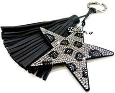 a star shaped key chain with black tassels and crystals in the shape of stars