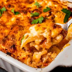 a close up of a spoon in a casserole dish with cheese and meat