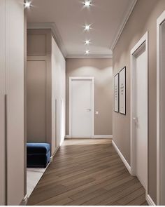 an empty hallway with wooden floors and white lights on the ceiling is lit by recessed lighting