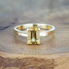 A stunning addition to the Storybook collection, this glowing citrine ring is a beautiful piece of statement jewellery. Inspired by a love of literature and the tactility of well-loved leather books this ring features a textured gold or silver Storybook band and a crisp emerald cut rich citrine clutched by solid 9ct yellow gold. Each ring is made to order, and no two rings are the same. You can be sure you're receiving a truly unique piece of jewellery, whether you're purchasing for yourself or Yellow Emerald-cut Topaz Ring, Faceted Citrine Promise Ring Jewelry, Yellow Citrine Topaz Ring Rectangular Shape, Yellow Gold Citrine Topaz Ring, Emerald Cut, Gold Citrine Baguette Cut Ring, Gold Sapphire Ring With Radiant Cut For Gift, Gold Radiant Cut Sapphire Ring Gift, Citrine Baguette Cut Ring For Anniversary, Citrine Gemstone Rings In Baguette Cut