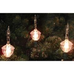 three lights are hanging from a christmas tree