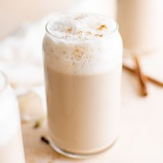 two glasses of milk sitting on top of a table