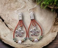 This is an adorable pair of boho leather dangle earrings. 1.5mm natural red brown leather cord has been formed into a teardrop shape that encompasses a flower charm. Seafoam picasso and metallic chocolate seed beads are strung onto the leather along with a flower spacer bead. The leather cord is glued into Tibetan style cord ends. Each earring weighs approximately 3.8 grams without an earwire. A nickel weighs approximately 5 grams. Choose your earwires from the drop down menu.  The earrings measure 2 1/2" long (with lever backs) from the top of the earwires to the bottom of the leather cord and are 3/4" wide. If you choose kidney wires it will add about 1" to the total length. MY OTHER SHOPS 🔸LEATHER BRACELETS, EARRINGS, AND NECKLACES: https://www.etsy.com/shop/CinfulBeadCreations 🔸PEYOT Handmade Brown Bohemian Teardrop Earrings, Nickel-free Bohemian Brown Teardrop Earrings, Bohemian Brown Teardrop Earrings For Gift, Bohemian Brown Teardrop Earrings Gift, Bohemian Brown Teardrop Earrings For Pierced Ears, Bohemian Brown Teardrop Nickel-free Earrings, Bohemian Brown Nickel-free Teardrop Earrings, Bohemian Brown Teardrop Earrings, Nickel-free Brown Teardrop Earrings For Jewelry Making