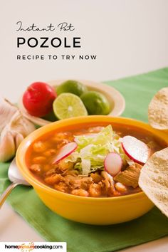 a yellow bowl filled with taco soup next to tortilla chips and limes