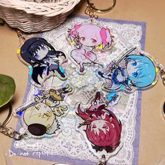 some anime key chains are laying on top of a doily next to a potted plant