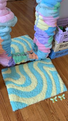 a pile of towels sitting on top of a wooden floor next to a blue rug