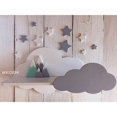 a shelf that has some paper stars on it and a cloud in the sky above it