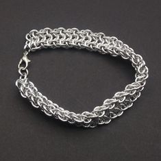 a silver chain bracelet on a black surface